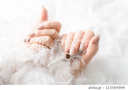 ネイルサロン・ジェルネイルをする女性（ベージュ・ブラウン・秋冬デザイン） 123564994