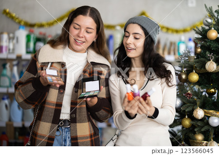 Women friends choose cosmetics and nail polish in decorated store Women friends choose cosmetics and nail polish in decorated store 123566045