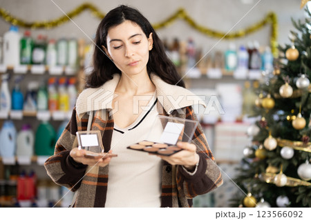 Young girl choosing cosmetics in retail store with New Year decoration Young girl choosing cosmetics in retail store with New Year decoration 123566092