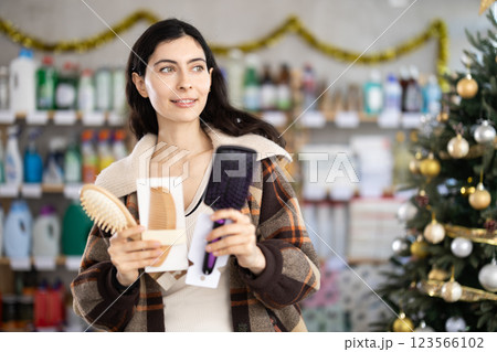Young girl choosing comb in store with New Year decoration Young girl choosing comb in store with New Year decoration 123566102