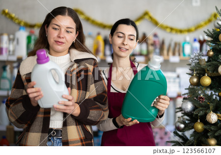 Woman seller offers detergent to young woman buyer Woman seller offers detergent to young woman buyer 123566107