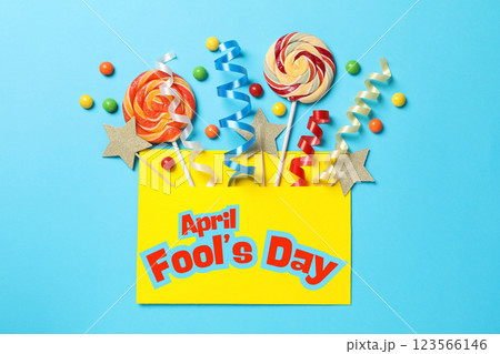 April Fool's Day, candy canes and confetti in an envelope on a blue background, top view 123566146
