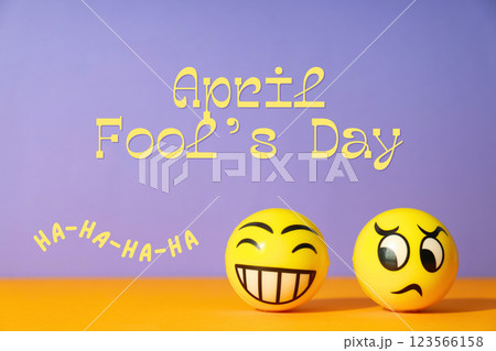 April Fool's Day, yellow balls with faces on a purple background with text April Fool's Day, yellow balls with faces on a purple background with text 123566158