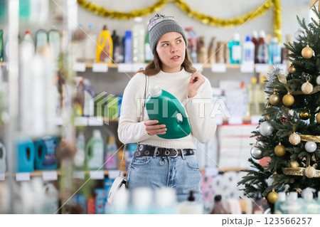 Young woman choosing laundry detergent in store during Christmas 123566257