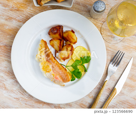 Tasty Gallineta fish fillet with sliced potatoes, served on dinner table Tasty Gallineta fish fillet with sliced potatoes, served on dinner table 123566690