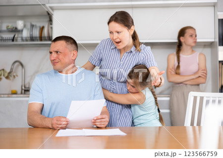 Wife yells at her husband who has not paid the loan. Children upset and scared Wife yells at her husband who has not paid the loan. Children upset and scared 123566759