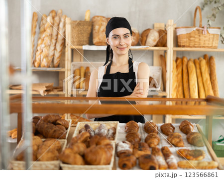 Young woman seller at showcase with pastries 123566861