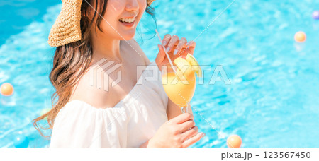 プールサイドでトロピカルジュースを飲む若いアジア人女性（リゾート・バカンス・バケーション） 123567450