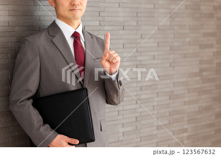 人差し指を立てるスーツ姿のミドル男性ビジネスマン 人差し指を立てるスーツ姿のミドル男性ビジネスマン 123567632