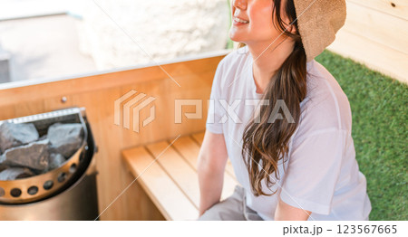 サウナに入っているサウナハットを被った若いアジア人女性 123567665