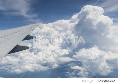 View of the plane's wing and beautiful clouds through the window during the flight. 123568332