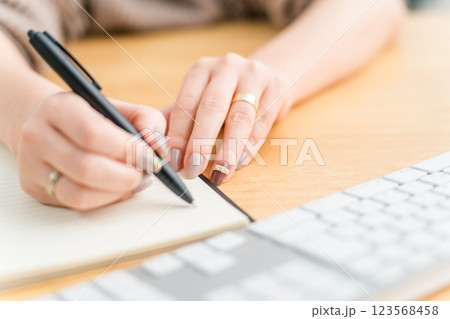 何かをメモする・書く女性(勉強・仕事・作家・ライター・日記・手帳・ネイル) 123568458