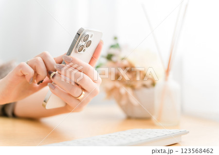 スマホ・スマートフォンの画面をタッチするネイルをした女性 スマホ・スマートフォンの画面をタッチするネイルをした女性 123568462