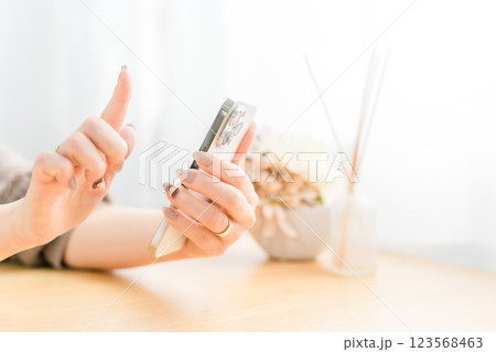 スマホ・スマートフォンの画面をタッチするネイルをした女性 スマホ・スマートフォンの画面をタッチするネイルをした女性 123568463