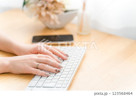 パソコンを使うネイルをした女性(仕事・ジェルネイル・ファッション・デザイナー) 123568464