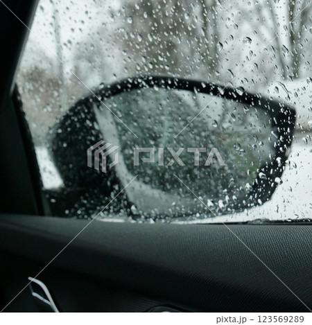 The heating system is trying to melt the snow stuck to the rearview mirror of the car. Morning after snowfall at open air parking The heating system is trying to melt the snow stuck to the rearview mirror of the car. Morning after snowfall at open air parking 123569289