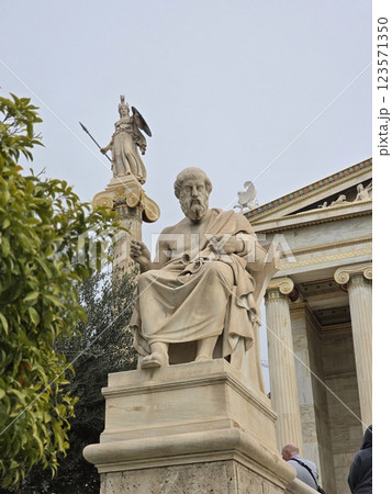 Renowned ancient philosopher statue in Athens with goddess Athena in the background 123571350