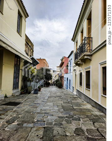 Cobblestone street in a historic neighborhood with colorful buildings and overcast sky 123571353