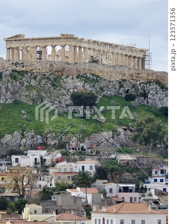 Acropolis of Athens stands majestically above modern buildings and green hills 123571356