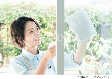 窓拭きをする若い女性 窓拭きをする若い女性 123572465