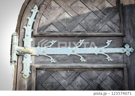 Vintage Wooden Door with Decorative Metal Hinge, Aged Texture and Architectural Detail 123574071