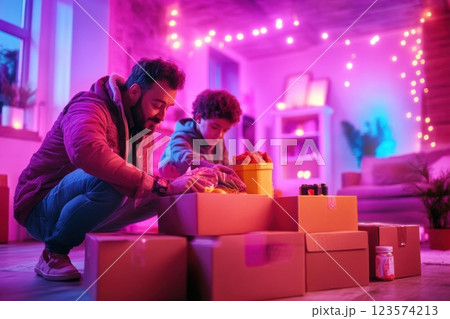 Father and son sharing quality time while packing food supplies in a cozy living room 123574213