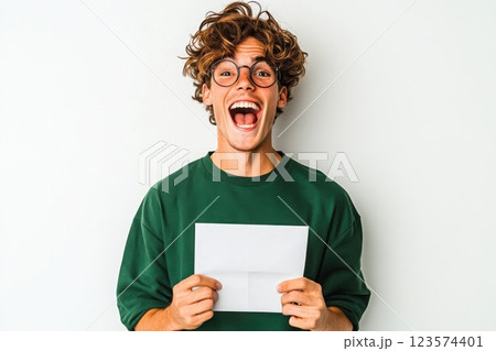 Young man gasping with excitement after receiving his university acceptance letter Young man gasping with excitement after receiving his university acceptance letter 123574401