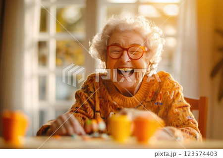 Elderly woman enjoys a joyful moment playing a board game with family in a cozy living room 123574403