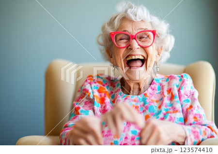 Elderly woman enjoying a joyful moment with laughter in her cozy chair Elderly woman enjoying a joyful moment with laughter in her cozy chair 123574410