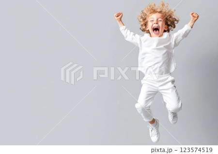 Joyful young man celebrating victory with a jump on a neutral background 123574519