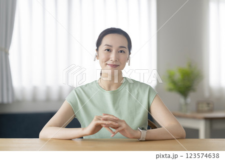 カメラ目線のイヤホンをつけた30代の女性 カメラ目線のイヤホンをつけた30代の女性 123574638