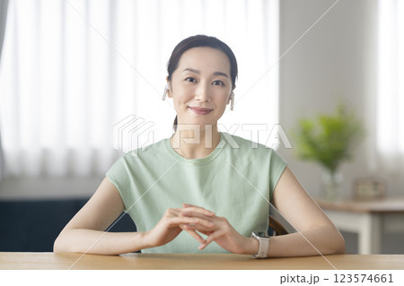 カメラ目線で微笑むイヤホンをつけた30代の女性 123574661