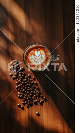 Frothy cappuccino with latte art on wooden table surrounded by coffee beans 123575016