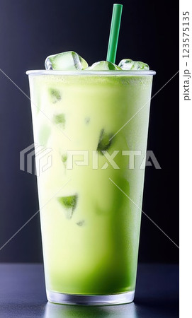 Vibrant iced matcha latte served in a clear glass with visible layers against a plain background 123575135