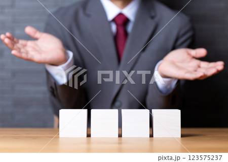 4つの白い木のブロックとスーツを着たミドル男性ビジネスマン 123575237