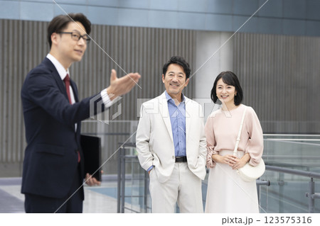 50代の夫婦を案内するミドルの営業マン 123575316