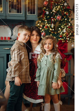 Beautiful mother, daughter and son at the Christmas tree.  123575373