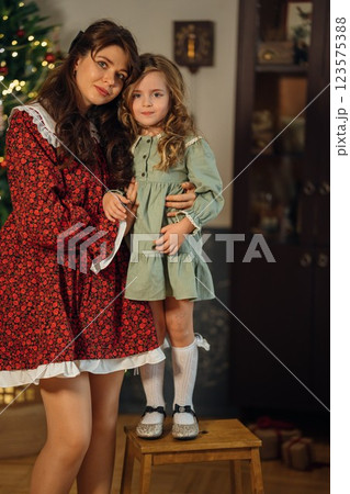 Beautiful mother and daughter at the Christmas tree. Beautiful mother and daughter at the Christmas tree. 123575388