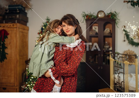 Beautiful mother and daughter at the Christmas tree. Beautiful mother and daughter at the Christmas tree. 123575389