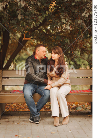 Couple sharing a tender moment on a park bench during autumn Couple sharing a tender moment on a park bench during autumn 123575400