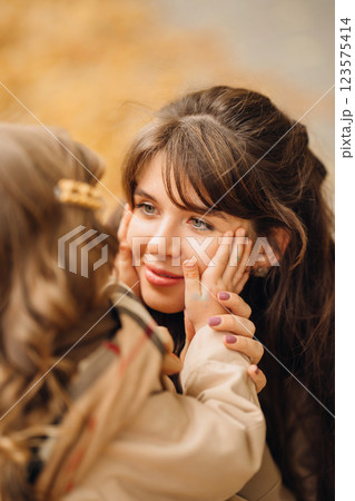 Loving mother and daughter sharing an intimate moment in autumn leaves 123575414