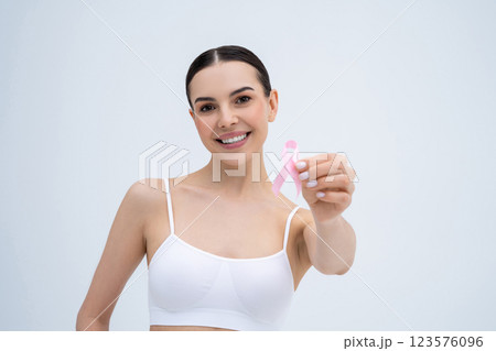 Smiling young woman holding a pink ribbon in hands 123576096