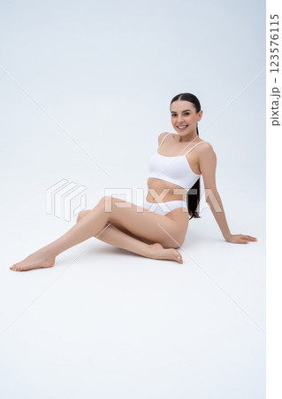 Pretty young caucasian young woman sitting on the floor on a white background Pretty young caucasian young woman sitting on the floor on a white background 123576115