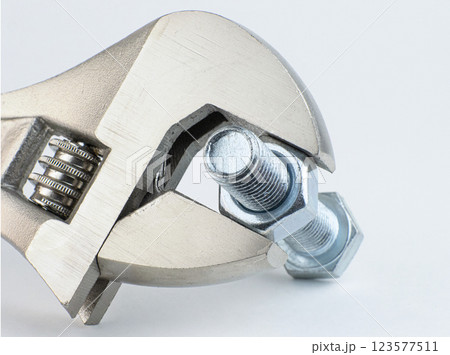 A wrench securely grips a metal bolt and nut for adjustment A wrench securely grips a metal bolt and nut for adjustment 123577511