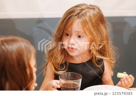 Beautiful little girl eating and drinking soda. Beautiful little girl eating and drinking soda. 123579385