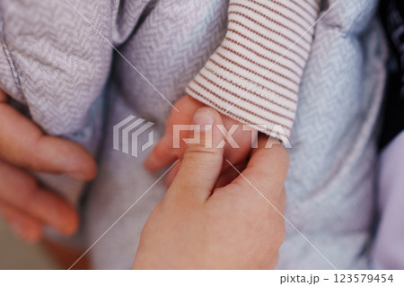 A child's hand holds a small baby's hand. A child's hand holds a small baby's hand. 123579454
