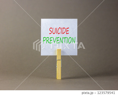 Suicide prevention symbol. Concept words Suicide prevention on beautiful white paper on clothespin. Beautiful grey table grey background. Psychological and suicide prevention concept. Copy space. 123579541