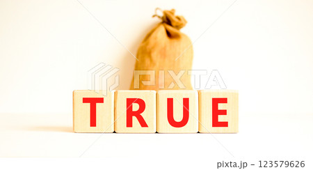 True symbol. Concept word True on beautiful wooden blocks. Beautiful canvas bag. Beautiful white table white background. Business, lifestyle, support and true concept. Copy space. 123579626