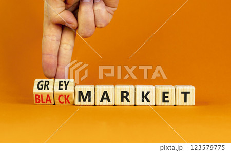 Black or grey market symbol. Concept words Black market or Grey market on beautiful wooden blocks. Beautiful orange background. Businessman hand. Business black or grey market concept. Copy space. 123579775