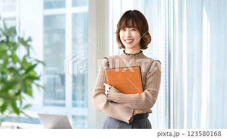バインダーを持つ笑顔の女性・ビジネスウーマン 123580168